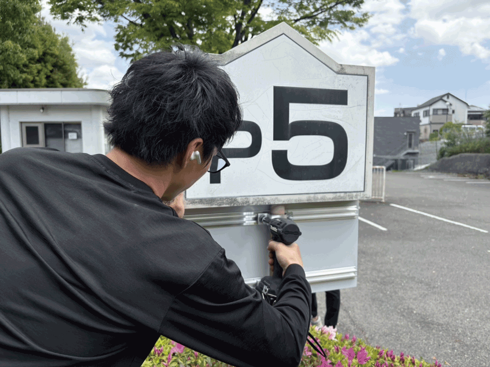 案内看板を修繕する作業員